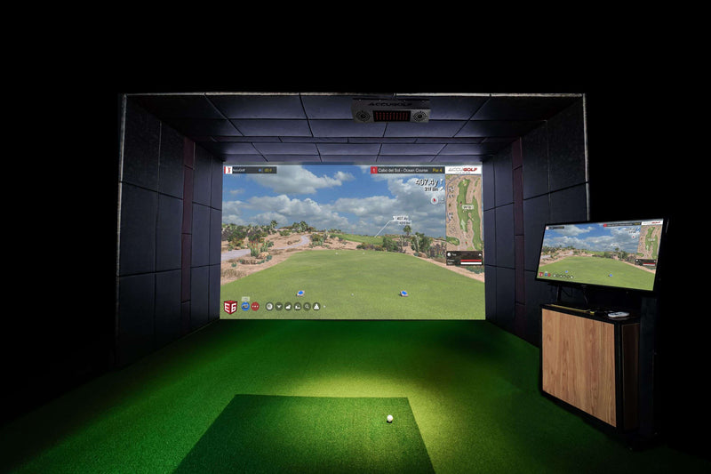 Indoor golf simulator setup with large screen and smaller monitor displaying a golf course.