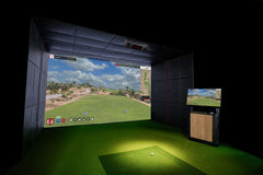 Golf simulator setup with a screen displaying a golf course and a smaller screen on a stand.